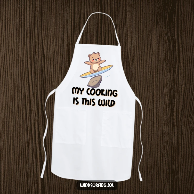 Funny apron featuring a bear comically attempting to surf on a surfboard while cooking, showcasing culinary and surfing mishaps.